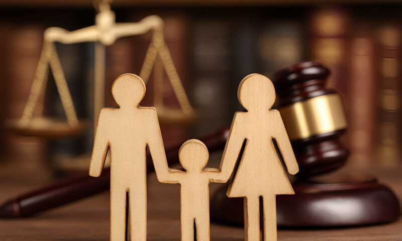 Wooden family figures are holding hands